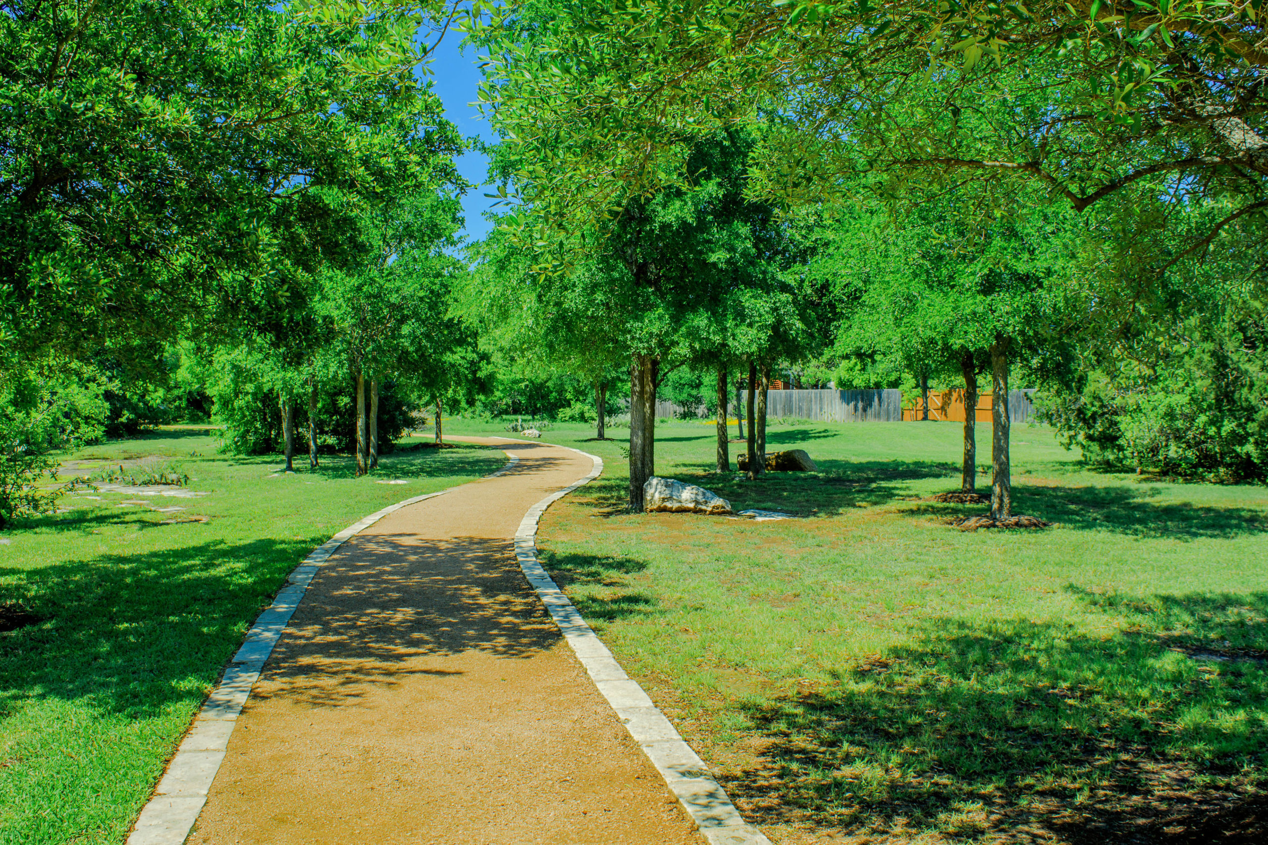 Picture of a gravel walking path surrounded by trees.