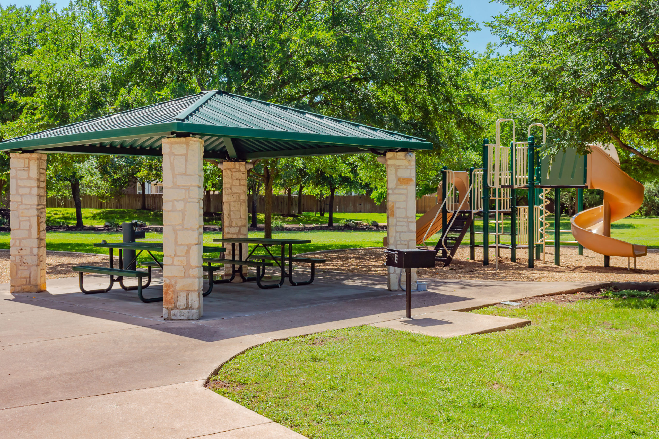 Picture of a playground and covered picnic tables.