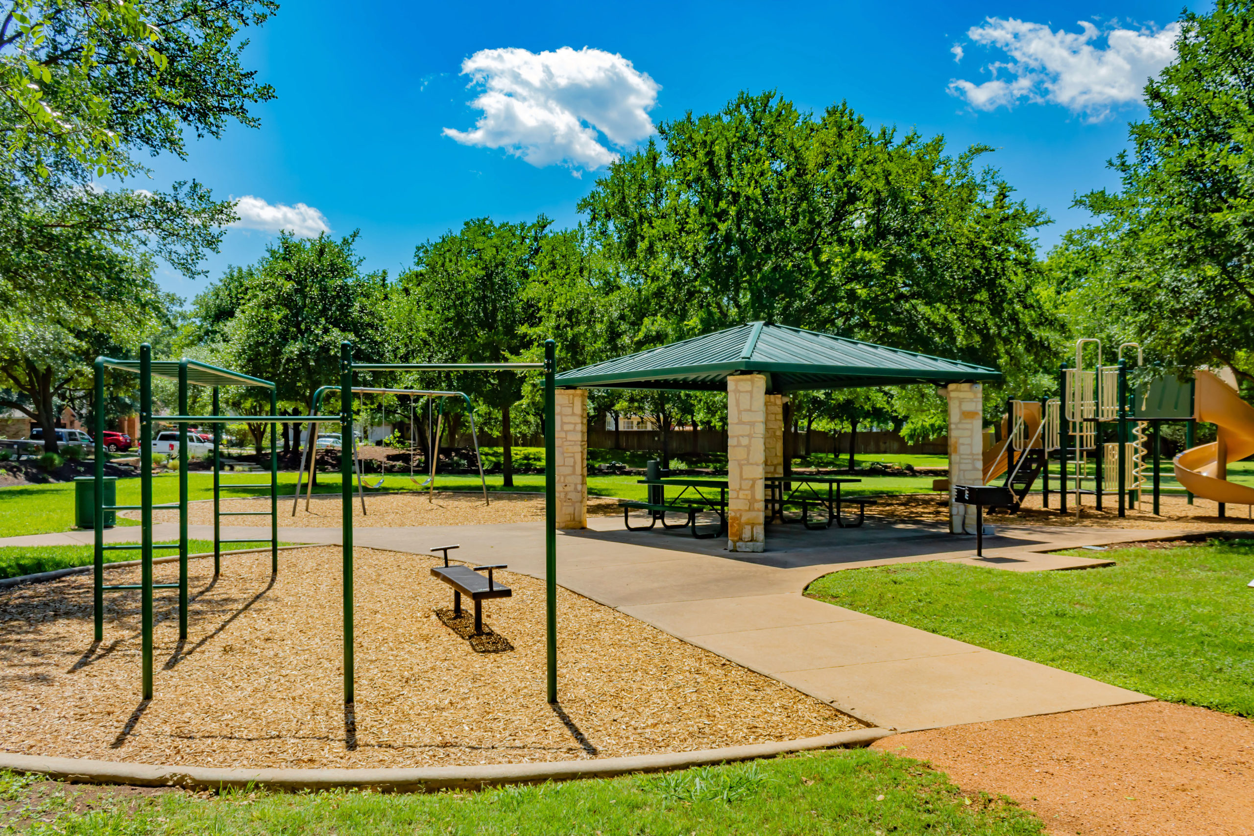 Picture of a playground and covered picnic tables.