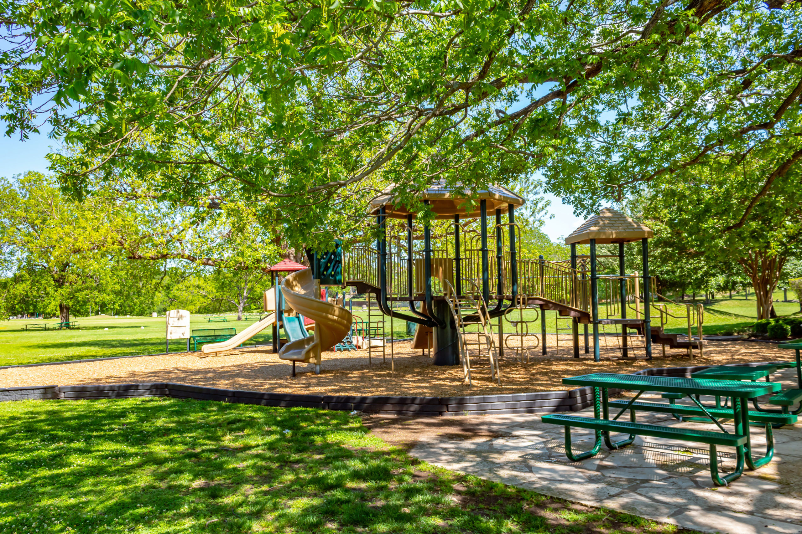 Picture of a playground and picnic tables.